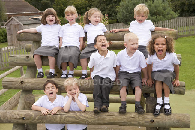 Young children sitting on benches and yelling — Stock Photo