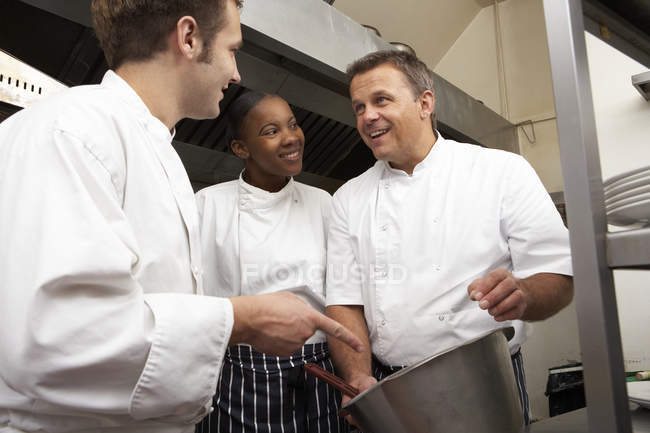 Koch bildet Auszubildende in Restaurantküche aus — Stockfoto