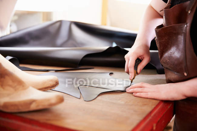 Sapateiro corte de couro em uma oficina — Fotografia de Stock