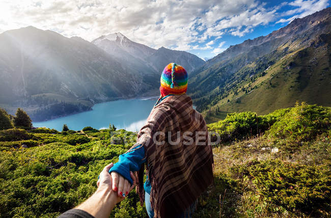 Donna turistica in cappello arcobaleno in montagna — Foto stock