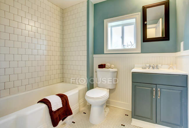Nuovo bagno blu ristrutturato con piastrelle bianche classiche . — Foto stock