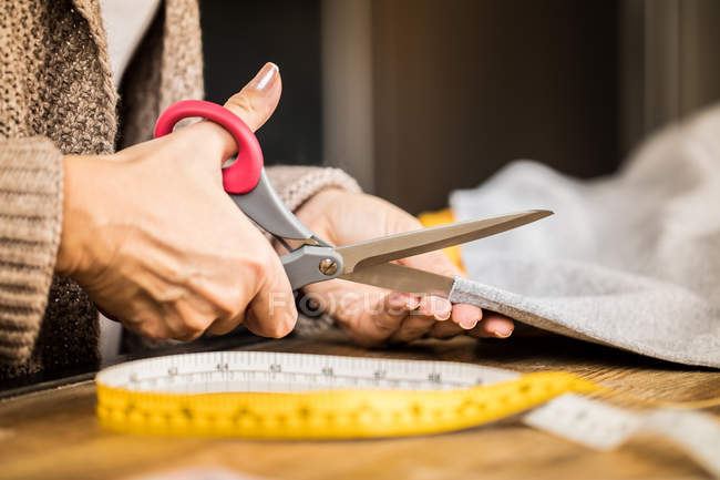 Woman cutting fabric — Stock Photo