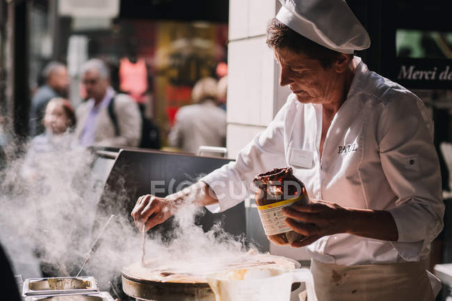 Vecchia signora preparare il cibo in strada — Foto stock