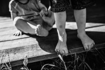 Дитячі ноги на дерев'яній терасі — стокове фото