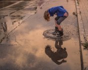 Menina salpicando água na estrada — Fotografia de Stock