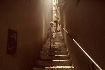 Niño caminando escaleras abajo - foto de stock
