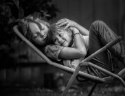 Хлопчик обіймає дівчинку на шезлонгу — стокове фото
