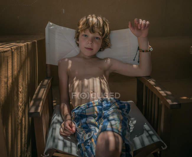 Імбирний хлопчик сидить у кріслі — стокове фото