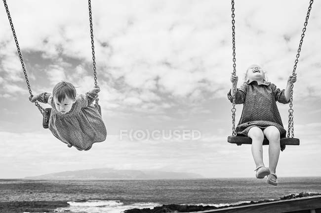 Duas meninas balançando ao ar livre — Fotografia de Stock