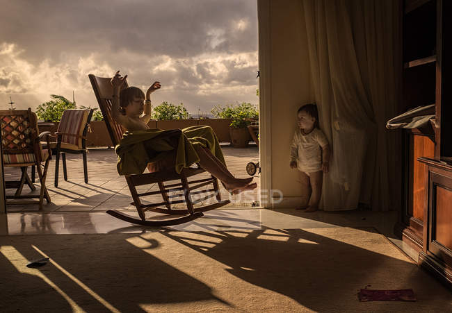 Хлопчик катається на кріслі в яскравому сонячному світлі — стокове фото
