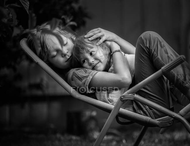 Junge umarmt Mädchen Kind auf Liege — Stockfoto