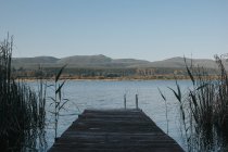 Empty wooden pier with mountain landscape — Stock Photo