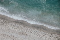 Onde maree che raggiungono la spiaggia sabbiosa — Foto stock