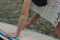Surfer fille essuie sa planche de surf — Photo de stock