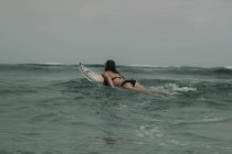 Menina com prancha de surf no oceano — Fotografia de Stock