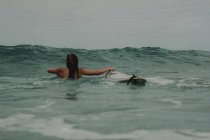 Surfista com prancha no oceano — Fotografia de Stock