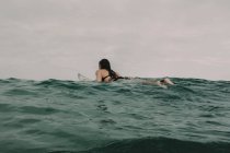 Surfista con tavola da surf nell'oceano — Foto stock