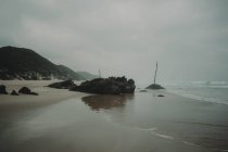 Скалистый берег с песчаным пляжем — стоковое фото
