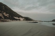 Скалистый берег с песчаным пляжем — стоковое фото