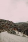 Estrada de terra acenando em montanhas rochosas — Fotografia de Stock