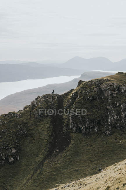 Турист, стоящий на горной гряде — стоковое фото