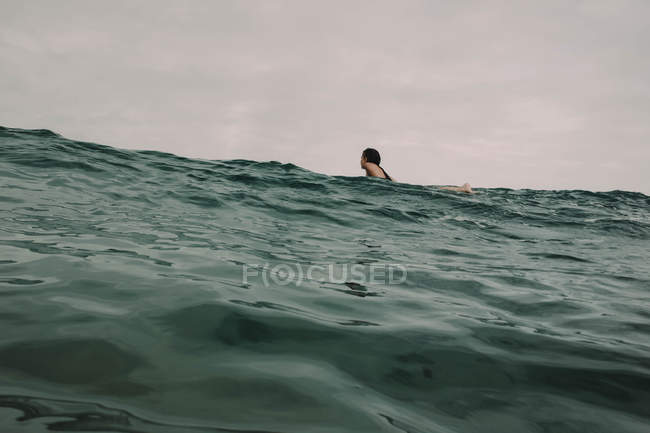 Surfista con tavola da surf nell'oceano — Foto stock
