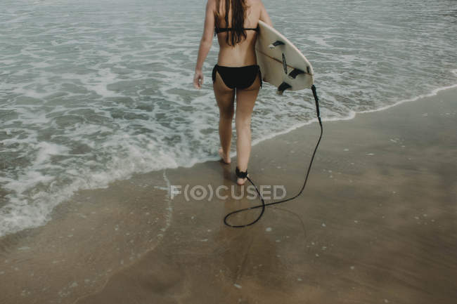 Menina com prancha pronta para surfar — Fotografia de Stock