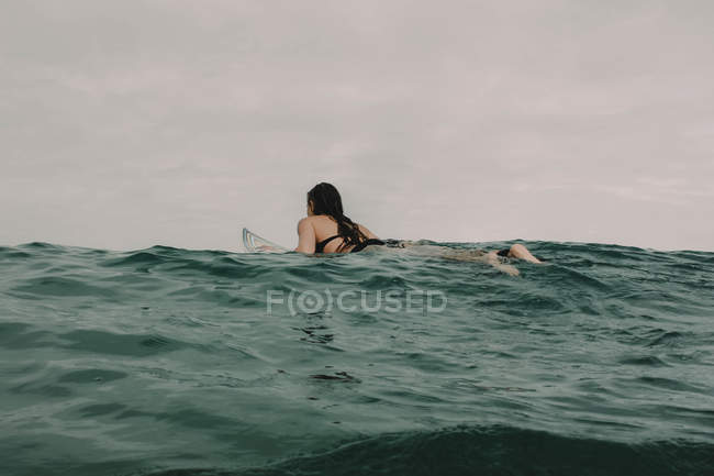 Surfista com prancha de surf no oceano — Fotografia de Stock