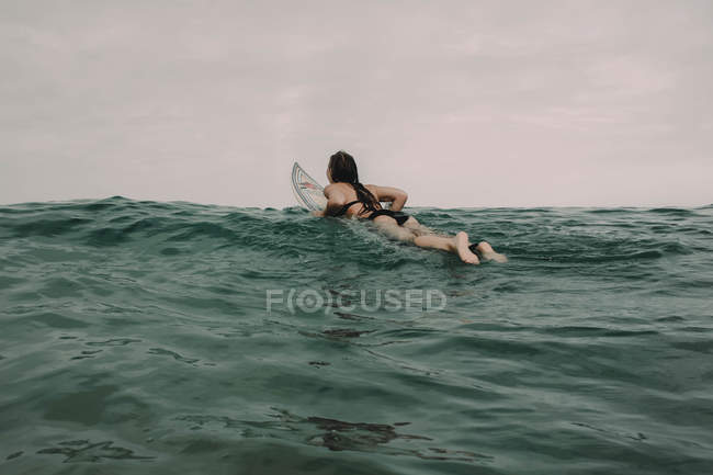 Surfista con tabla de surf en el océano - foto de stock