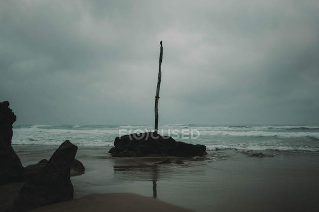 Rocky shore with pillar — Stock Photo