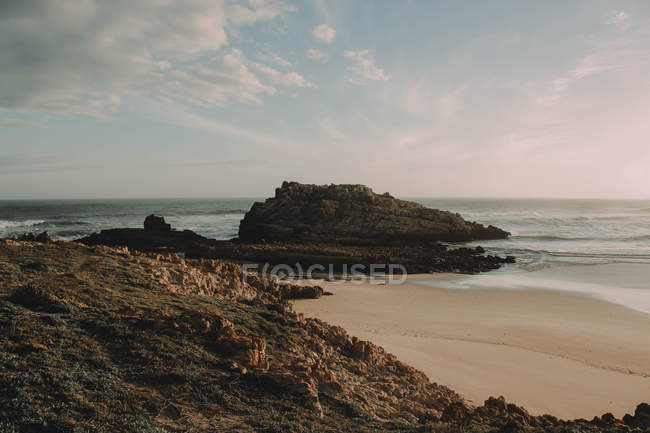 Rocky shore with sandy beach — Stock Photo