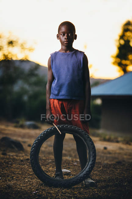 African boy with stick and wheel — Stock Photo