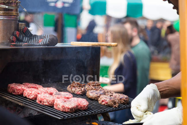 Hamburger di manzo grigliati sulla griglia del banco alimentare . — Foto stock