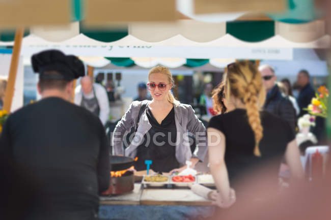 Donna che compra pasto al festival del cibo di strada . — Foto stock