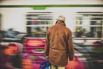 Old man standing in front train — Stock Photo