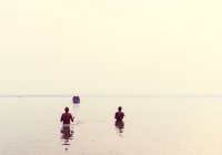 Hombres de pie en el agua cintura-alto - foto de stock