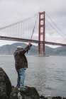 Hombre pescando cerca de Golden Gate Bridge - foto de stock