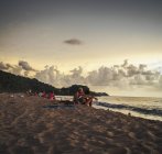 Люди сидять на піщаному пляжі — стокове фото