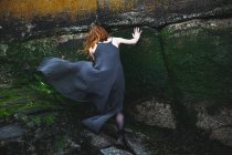 Девушка возле каменной стены — стоковое фото