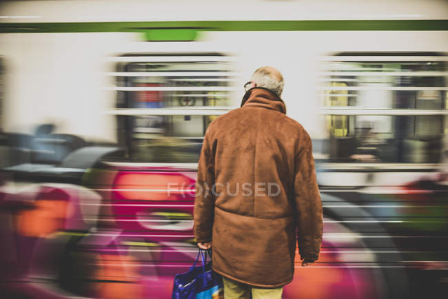 Old man standing in front train — Stock Photo