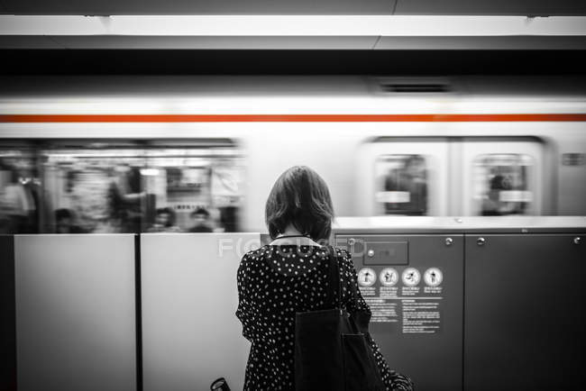 Дівчина стоїть перед рухомим поїздом — стокове фото