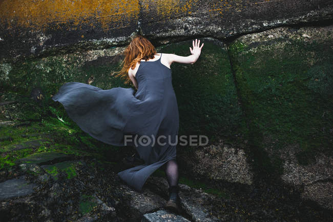 Девушка возле каменной стены — стоковое фото