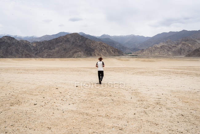 Hombre caminando en el desierto - foto de stock