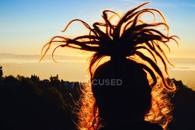 Girl with updo dreadlocks on sunset — Stock Photo