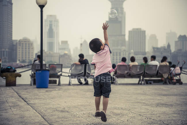 Маленький хлопчик грає з бульбашками — стокове фото