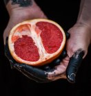 Руки женщины держат грейпфрут — стоковое фото