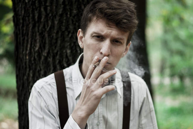 Joven fumando cigarrillo - foto de stock