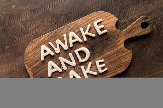 Edible lettering on cutting board — Stock Photo