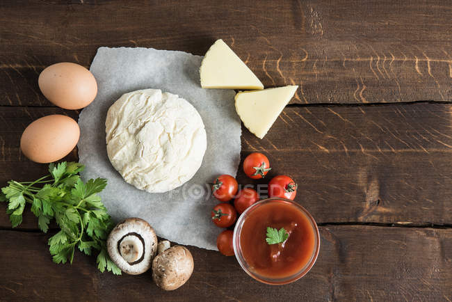 Masa con ingredientes para preparar pizza - foto de stock