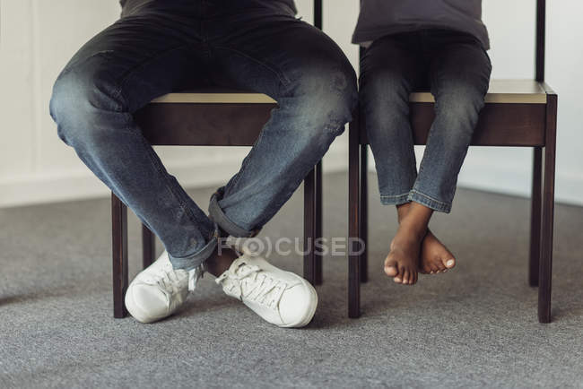 Ноги отца и сына под столом — стоковое фото